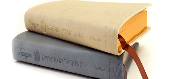 Two books stacked; grey copy of Evening by Evening on bottom, beige copy of Morning by Morning on top