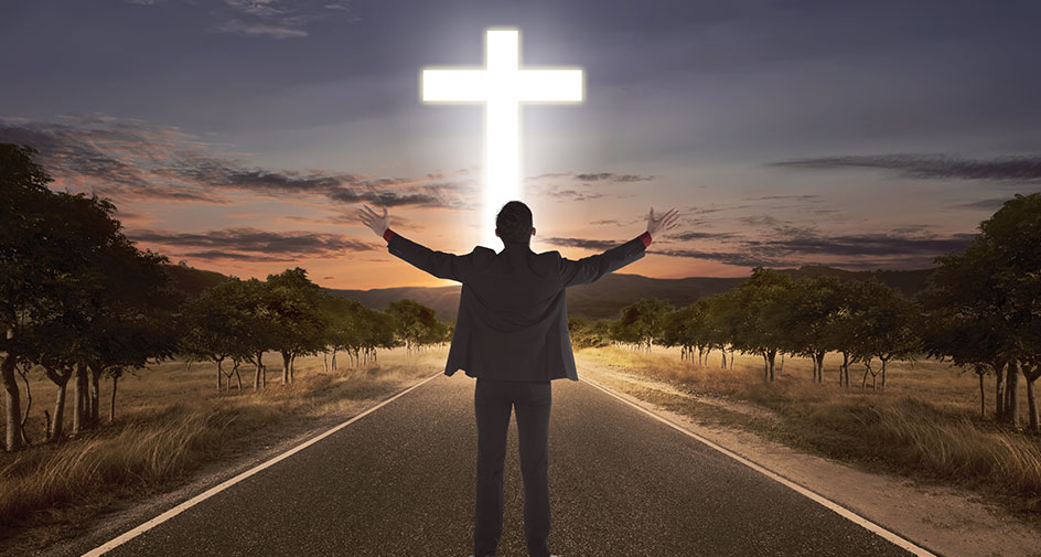 A wooden walkway over tall, dry grass leading to a glowing cross representing salvation.