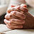 A pair of hands clasped together praying for others.